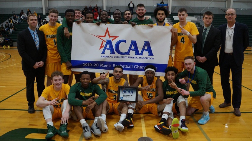 The SUNY Delhi men's basketball team holds up their ACAA Championship banner to celebrate their second straight ACAA title.