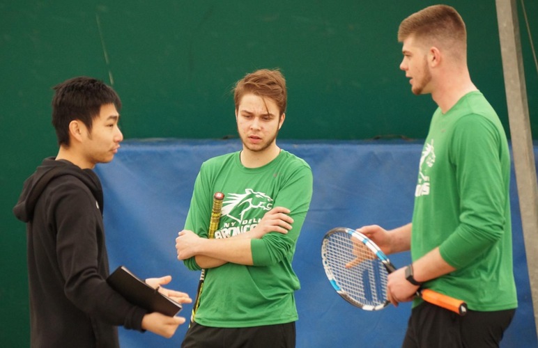 Coach Lac Van instructing doubles team Christopher Balogh and Payton Dean during their match. 
