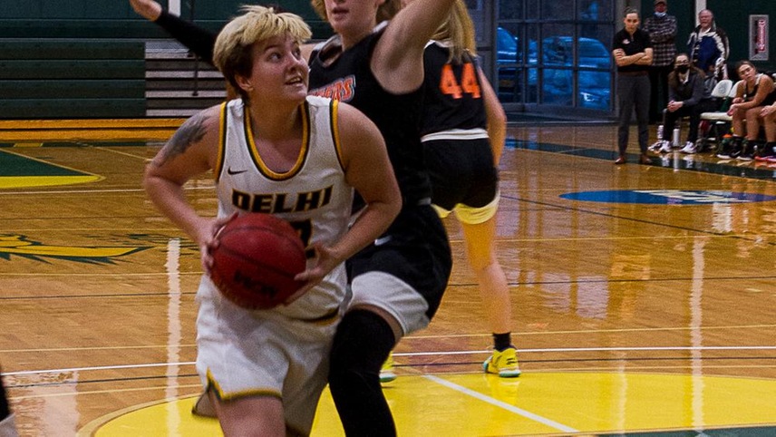 women's basketball player driving towards the basket.