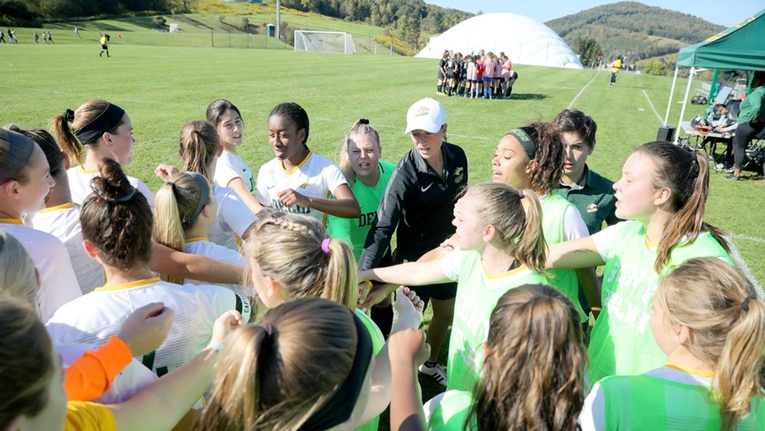 The women's soccer team in a huddle prior to a match.