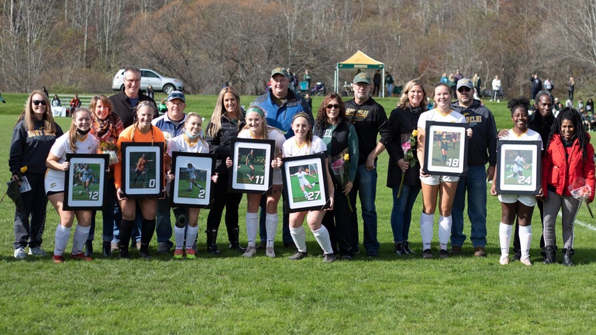 soccer players posing for pictures with families on senior day