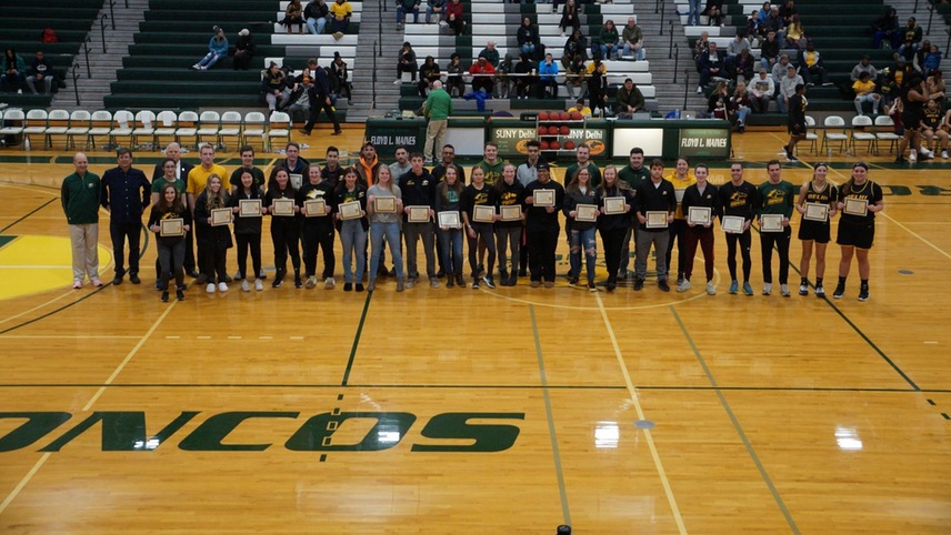 The SUNY Delhi Scholar Athletes pose on the basketball court for a photo.