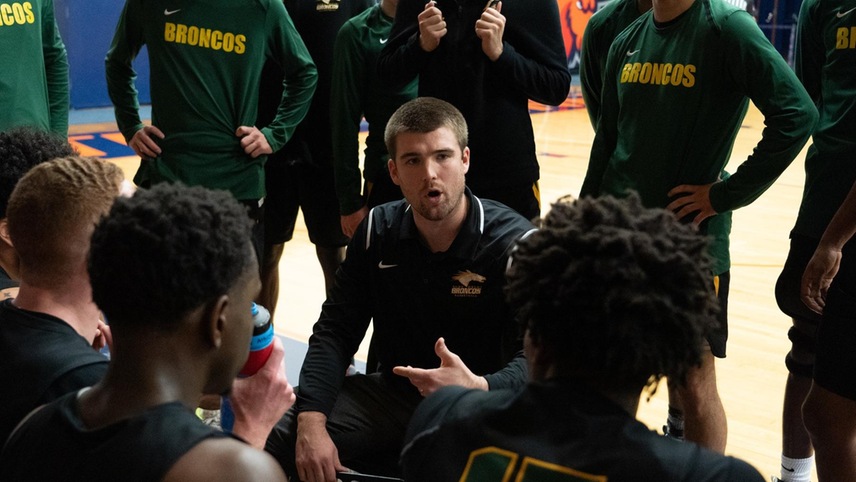 Head coach Zack Thomsen talks to his team on the bench during a timeout.