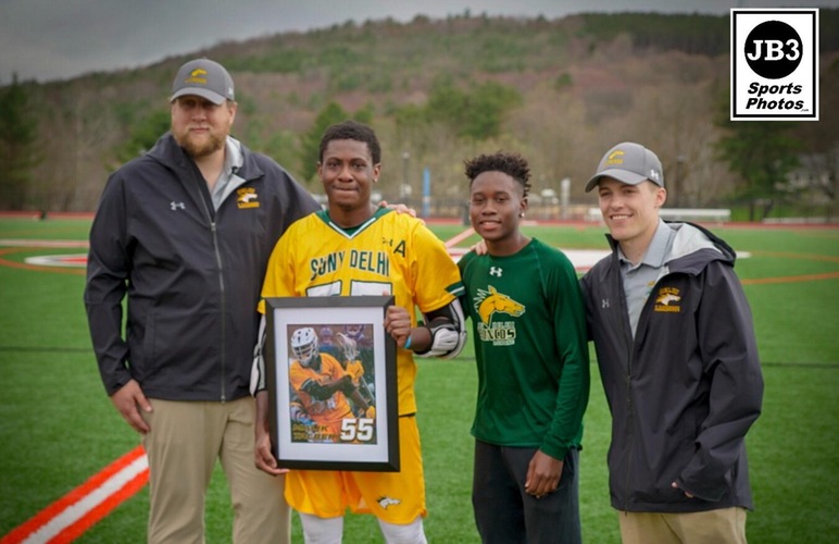 Malik Talbert alongside head coach Sam Miller, his brother, and assistant coach Zach Cook during his senior day recognition. 