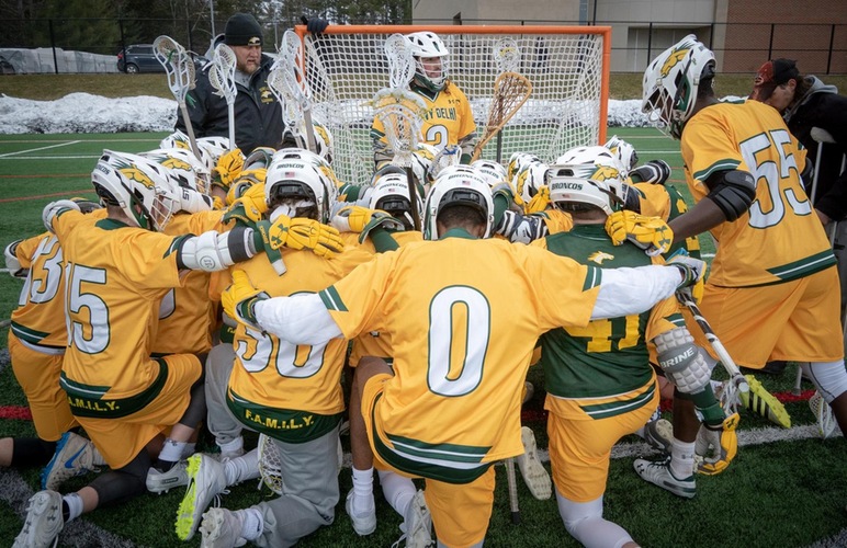 The men's lacrosse team huddles up in front of the goal for their pre-game prayer prior to a contest. 