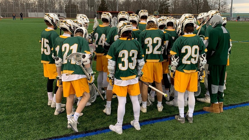 The men's lacrosse team huddles during a break in the game. 