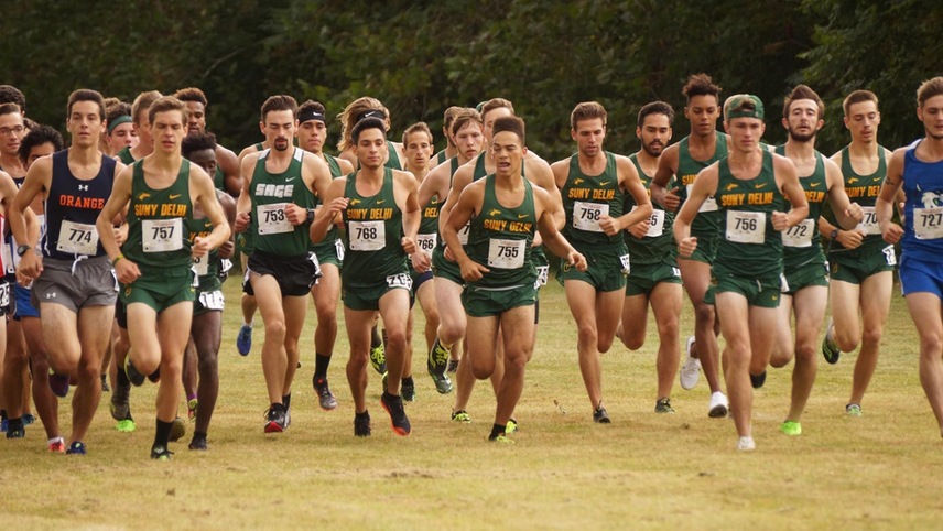The men's cross country team runs out of the shoot to begin the race.