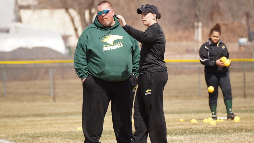 Coaches Greg Keesler and Meagan Hillard conversing on the field before a game.