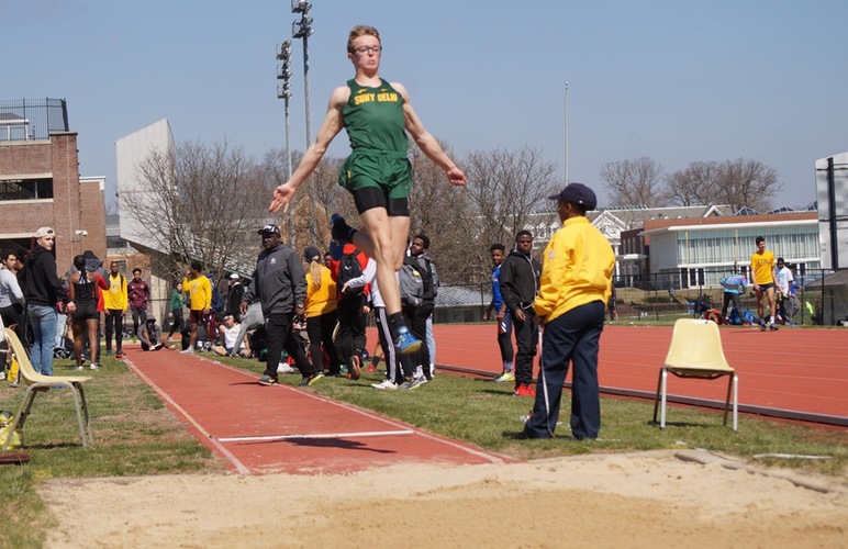 Alex Irving in mid-air attempting a triple jump. 