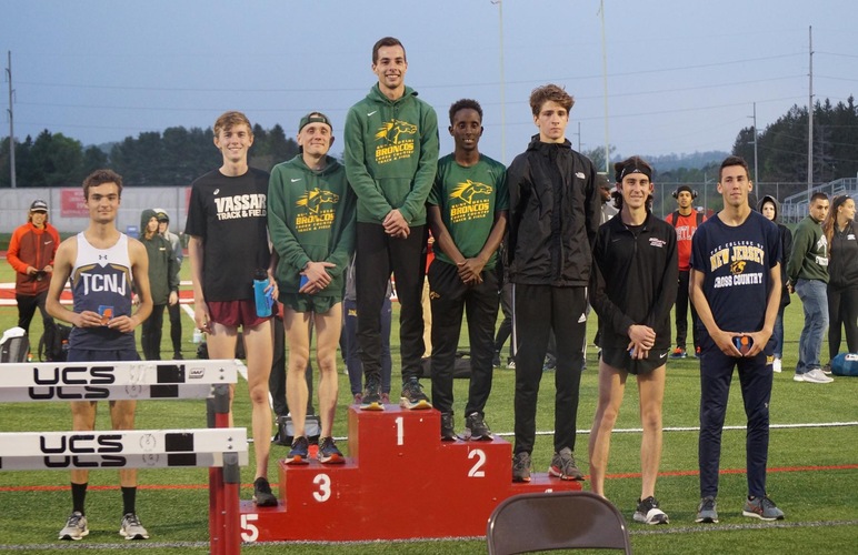 Kobie Lane, Nick Arnecke and Abshir Yerow standing on the top three podium spots following the 5K race at the AARTFC Championships.