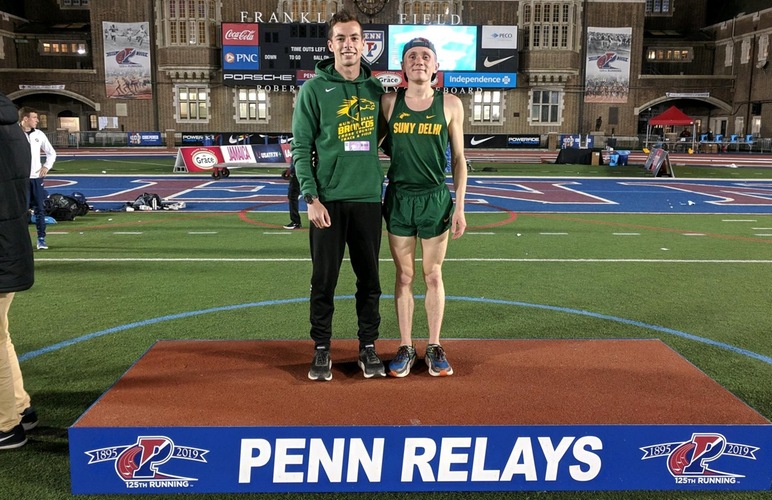 Runners Kobie Lane and Nick Arnecke standing on the podium at Penn Relays. 