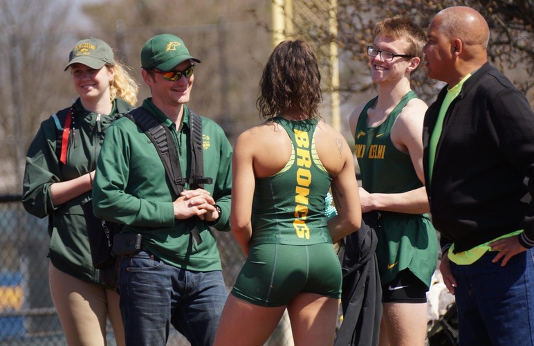 Coach Robb Munro interacting with his student-athletes between competitions at a track meet.