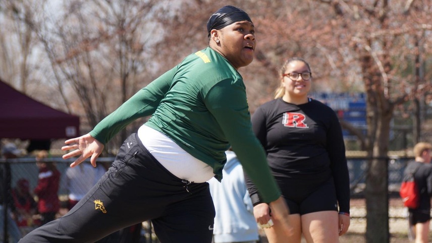 Akilah Sanders completing a shot put and watching where it lands.