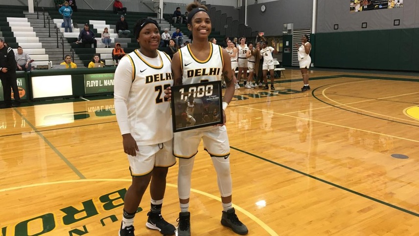 Kiera Holland accepting her 1,000 career point award from teammate and fellow 1,000-point scorer Samiaya Salley.