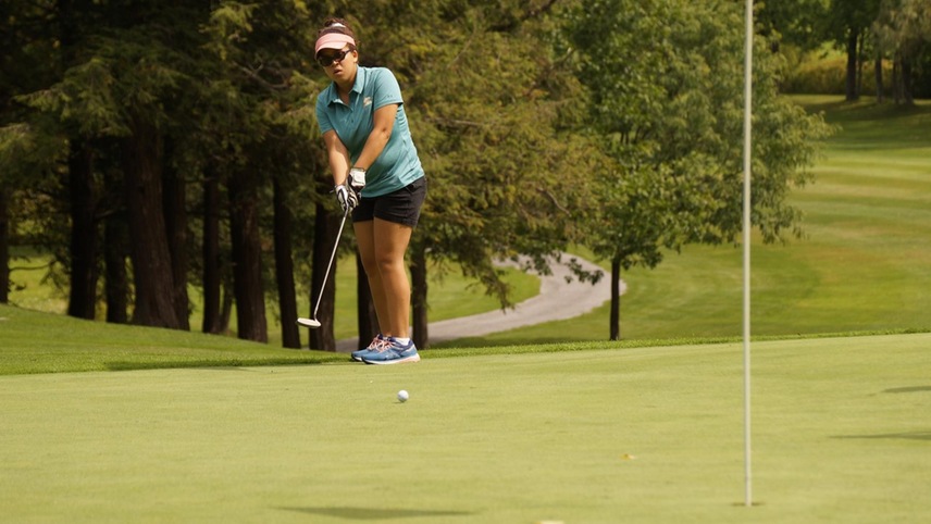 Ava Rossi puts a ball on to the green with the pin in the forefront.