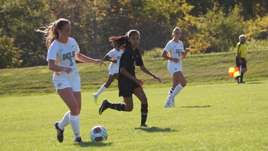 Reanen Goodspeed bringing the ball up the field with an opponent running alongside her.