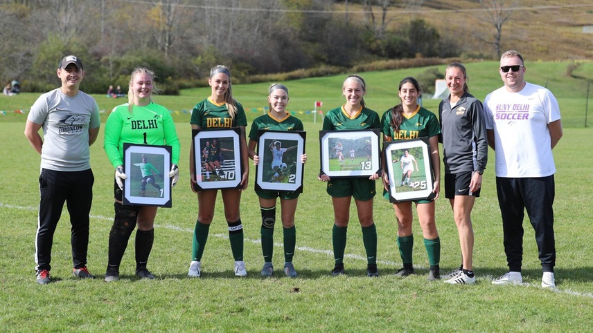 The graduating players pose with their commemorative photos alongside their coaches.