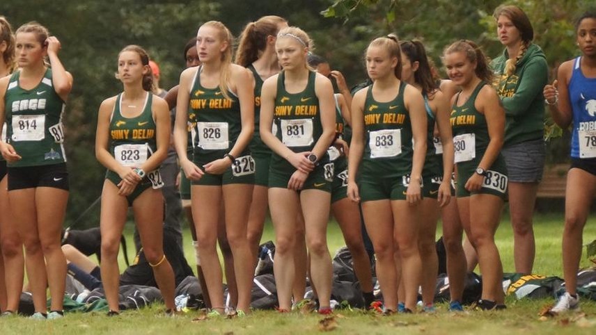 The women's cross country team standing in the box waiting for the race to start.