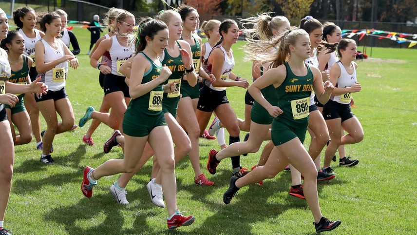 The women's cross country team running out of the shoot to begin a race.